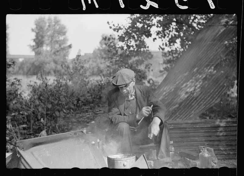 Man in hobo jungle killing turtle to make soup, Minneapolis, Minnesota