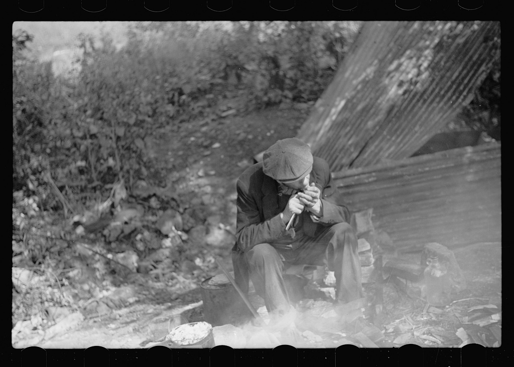 Man in hobo jungle killing turtle to make soup, Minneapolis, Minnesota