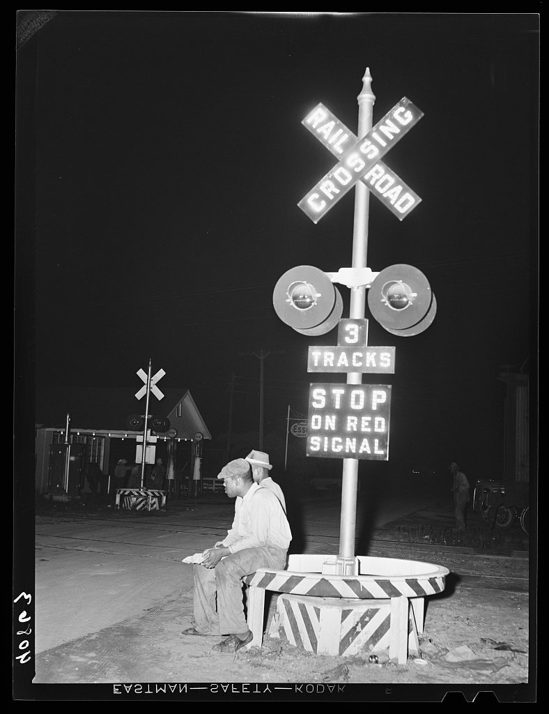 Migratory agricultural workers having supper at the railroad crossing at Camden, North Carolina