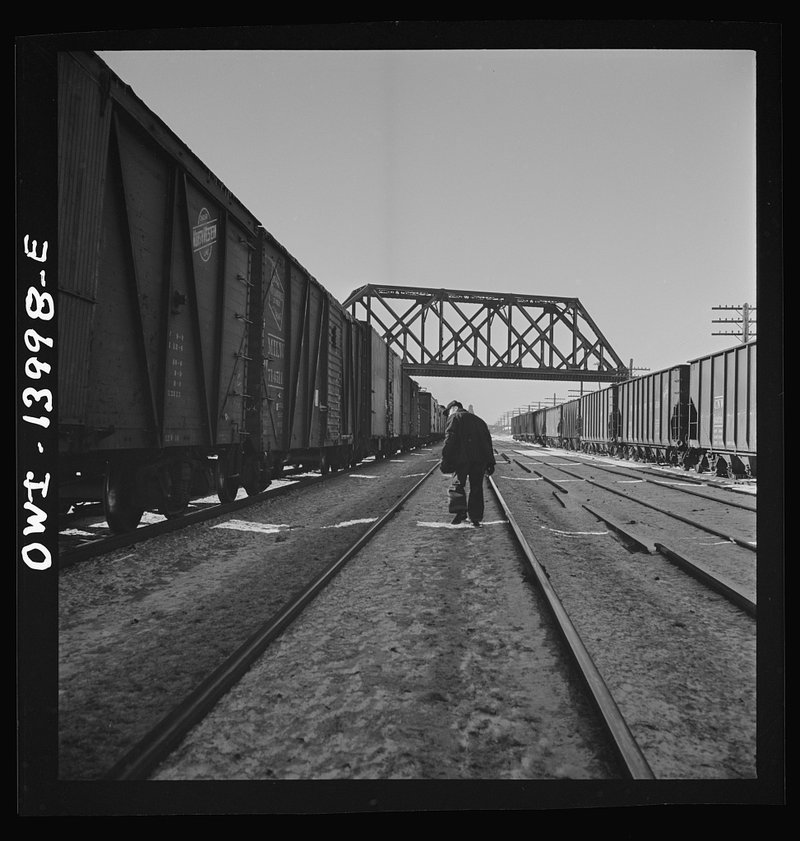 Chicago and North Western brakemen inspecting a freight for hotboxes at DeKalb, Illinois